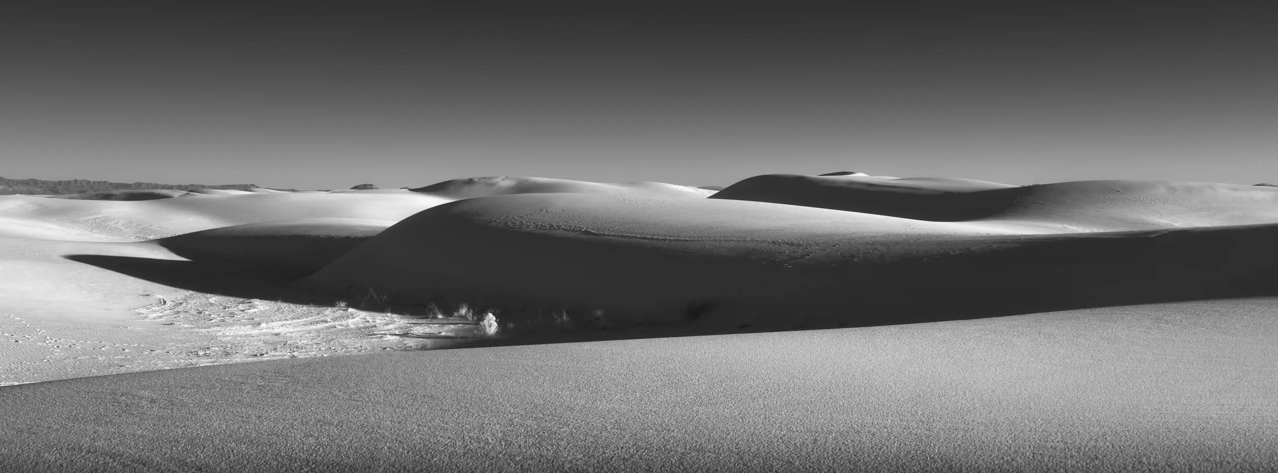 Black and white panoramic view across white sand dunes