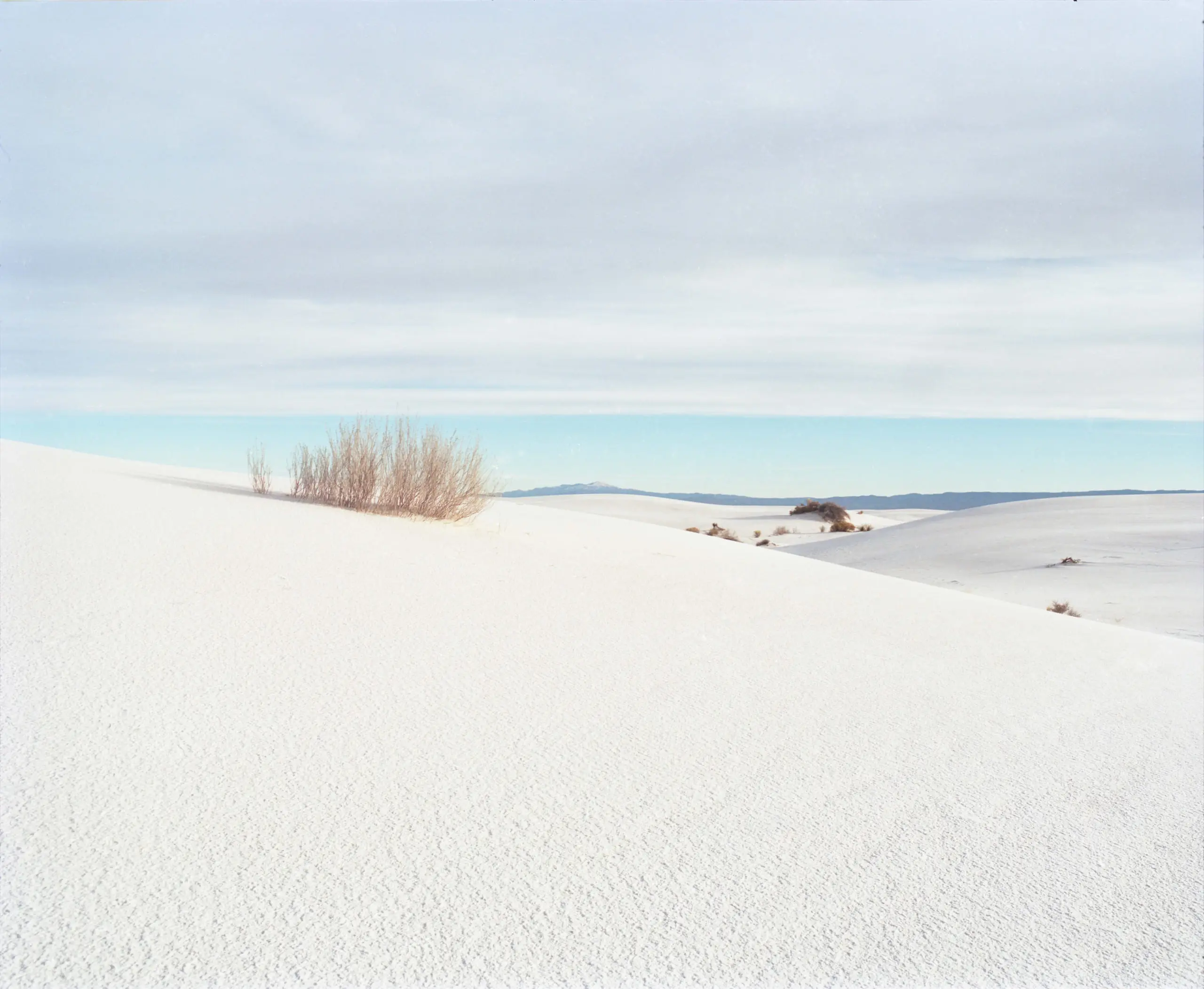 Soft colour film photograph of white sand